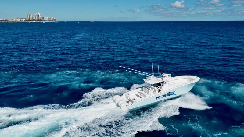 Slide: The Image of 2020 SeaHunter 46 CTS cruising on open ocean near city skyline. - 5