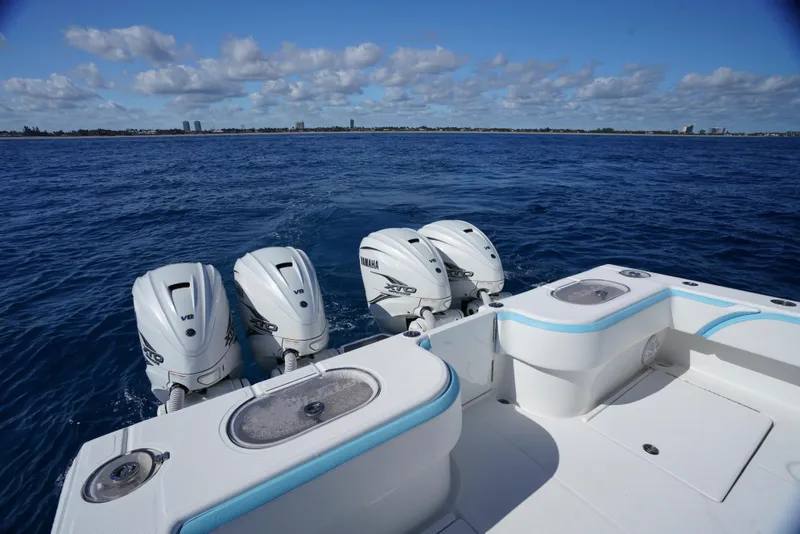 Slide: The Image of 2020 SeaHunter 46 CTS boat with four powerful outboard engines on open water. - 8
