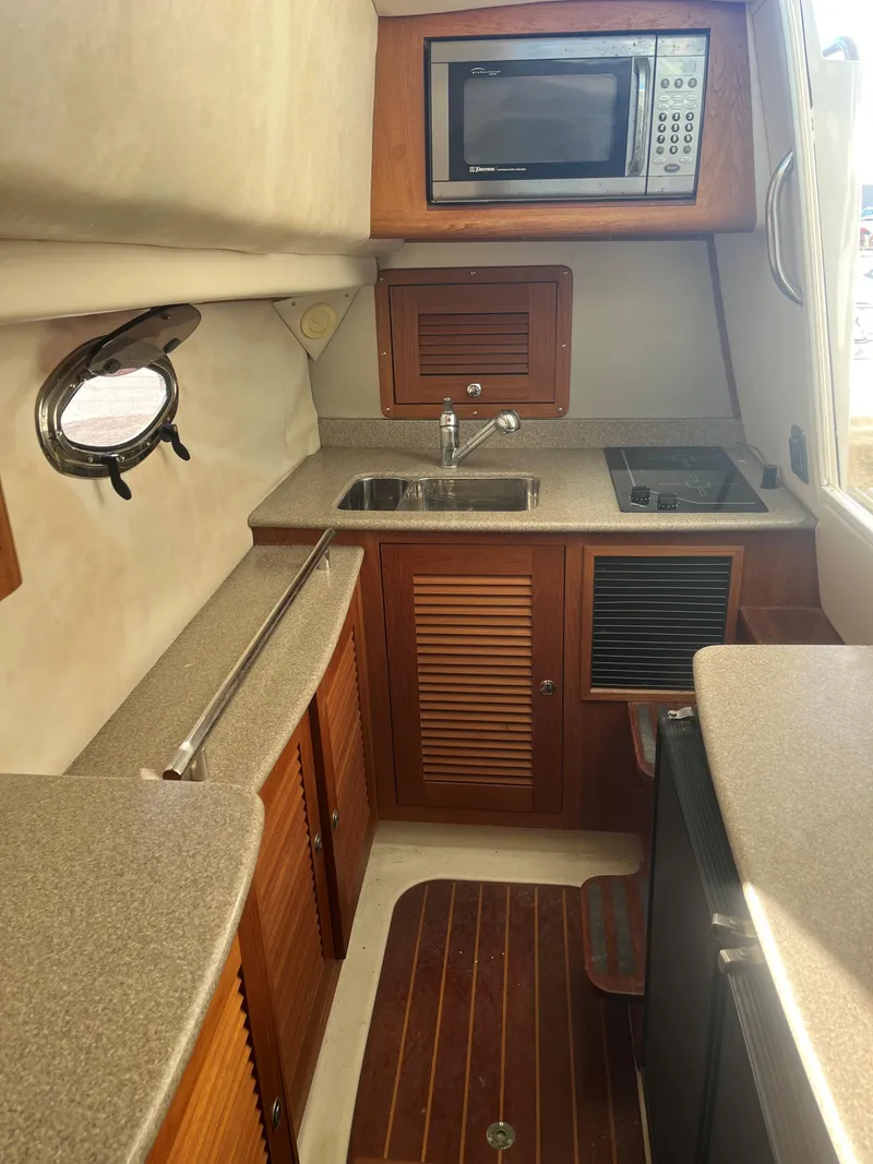 Slide: The Image of 2004 Glacier Bay 3480 Ocean Runner boat kitchen with microwave, sink, and stove. - 10