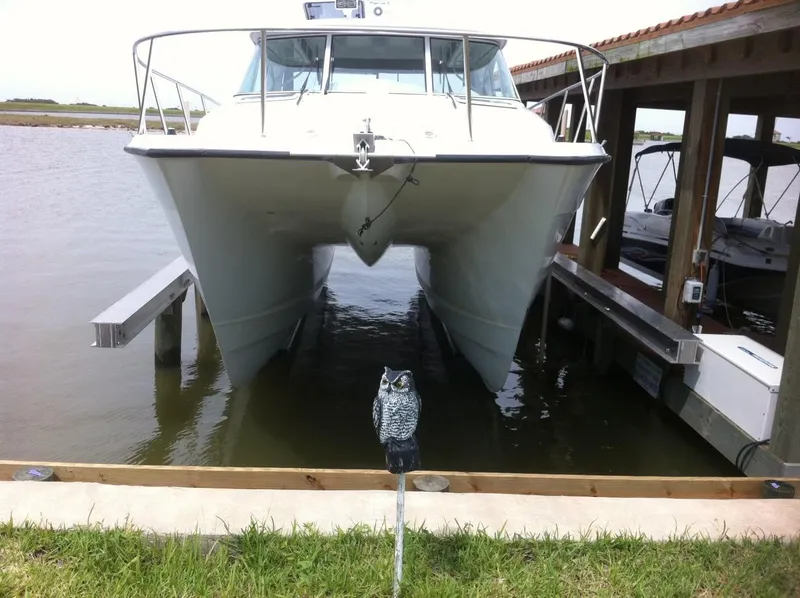 Slide: The Image of 2004 Glacier Bay 3480 Ocean Runner catamaran docked with decorative owl in foreground. - 3
