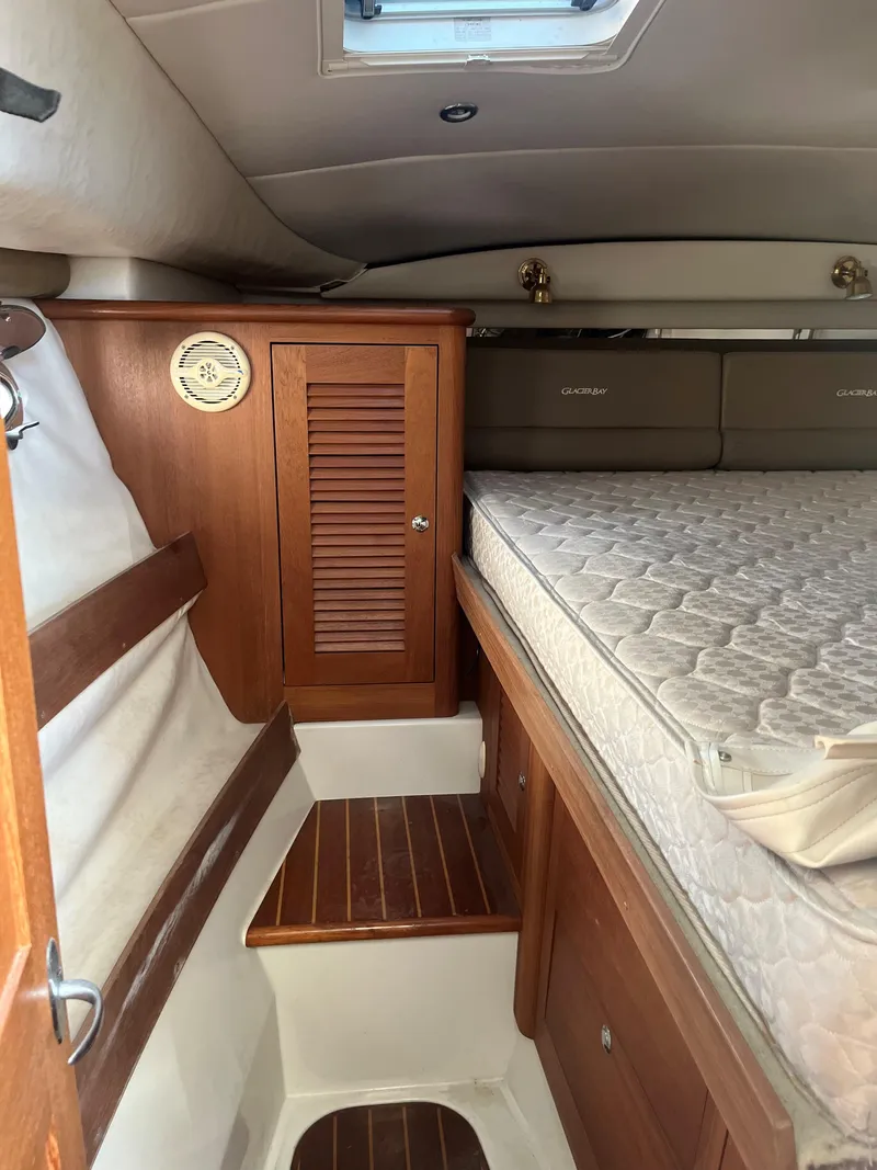 Slide: The Image of 2004 Glacier Bay 3480 Ocean Runner cabin interior with wooden cabinetry and mattress. - 7