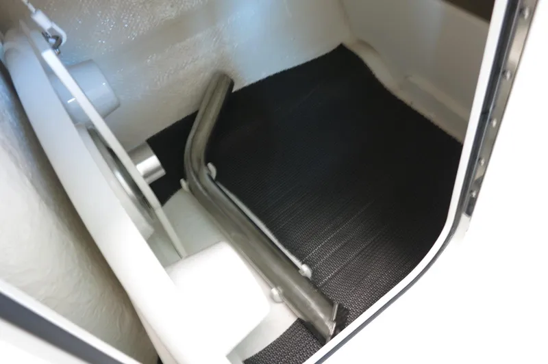 Slide: The Image of 2024 Chaparral 23 SSi OB storage compartment with black mat and metal support. - 16