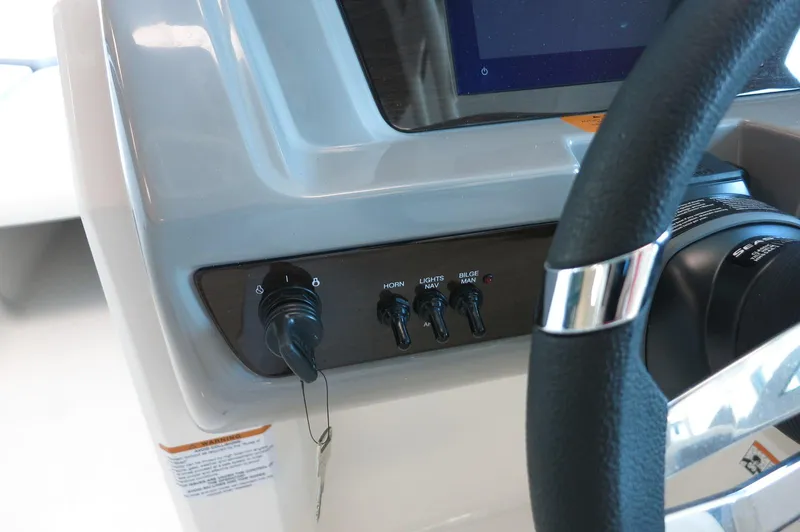 Slide: The Image of 2024 Chaparral 23 SSi OB dashboard with steering wheel and control switches. - 19