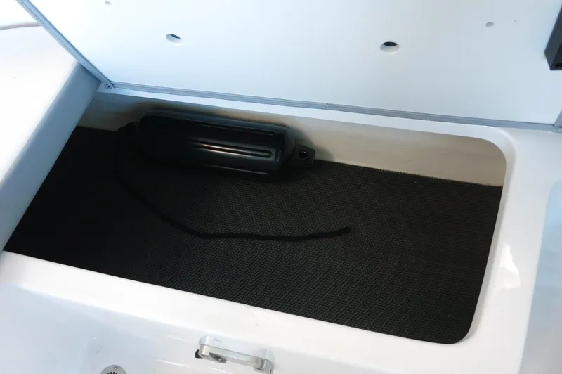 Slide: The Image of 2024 Chaparral 23 SSi OB storage compartment with black mat and fender. - 28