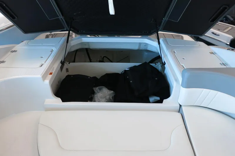 Slide: The Image of 2024 Chaparral 23 SSi OB boat interior storage compartment with open hatch. - 29