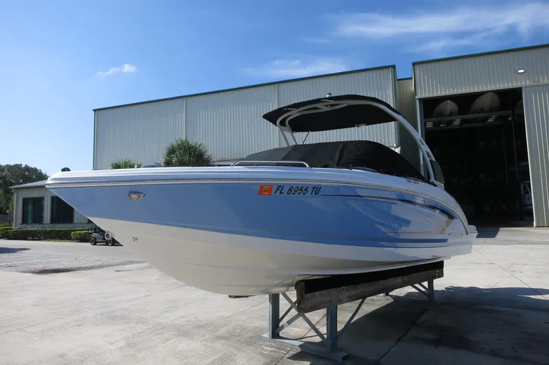 Slide: The Image of 2024 Chaparral 23 SSi OB boat on display outside a warehouse. - 3