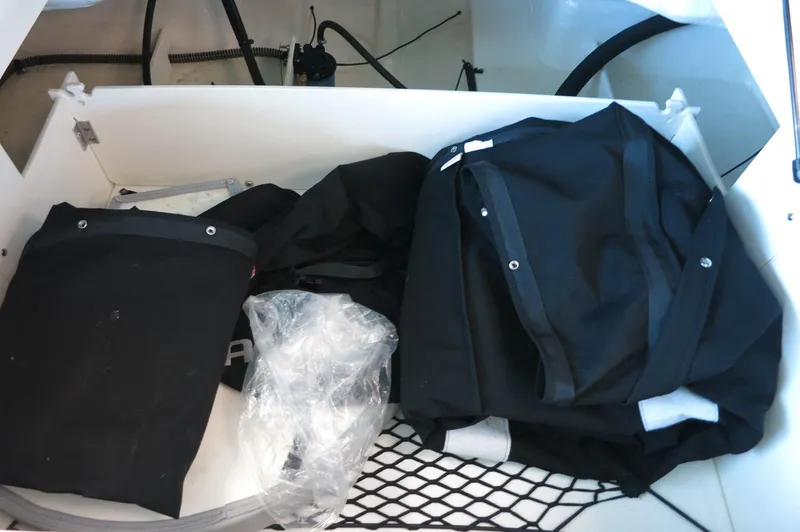 Slide: The Image of Storage compartment of 2024 Chaparral 23 SSi OB boat with bags and netting. - 30