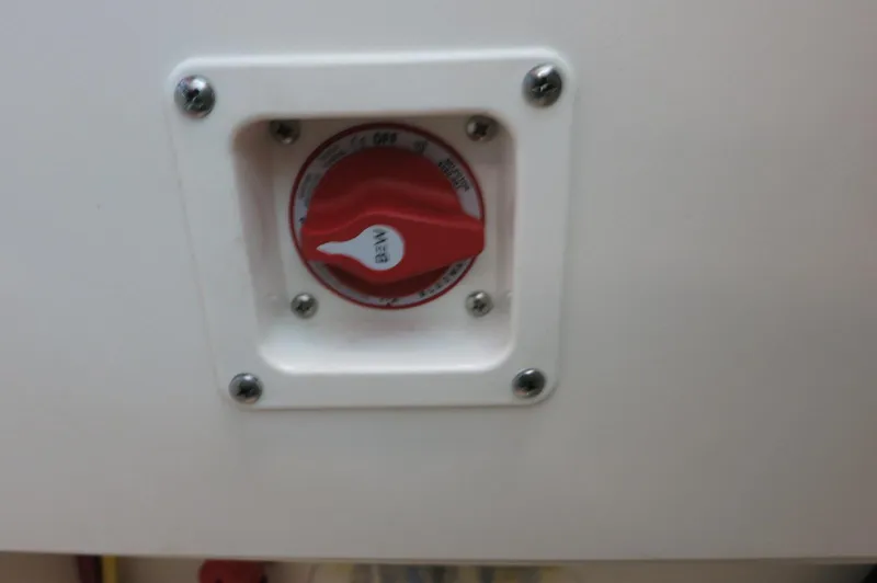 Slide: The Image of 2024 Chaparral 23 SSi OB battery switch, red knob, white panel. - 35