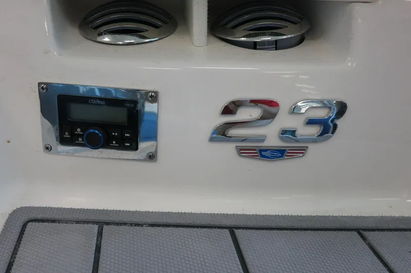 Slide: The Image of 2024 Chaparral 23 SSi OB boat dashboard with stereo system and model emblem. - 5