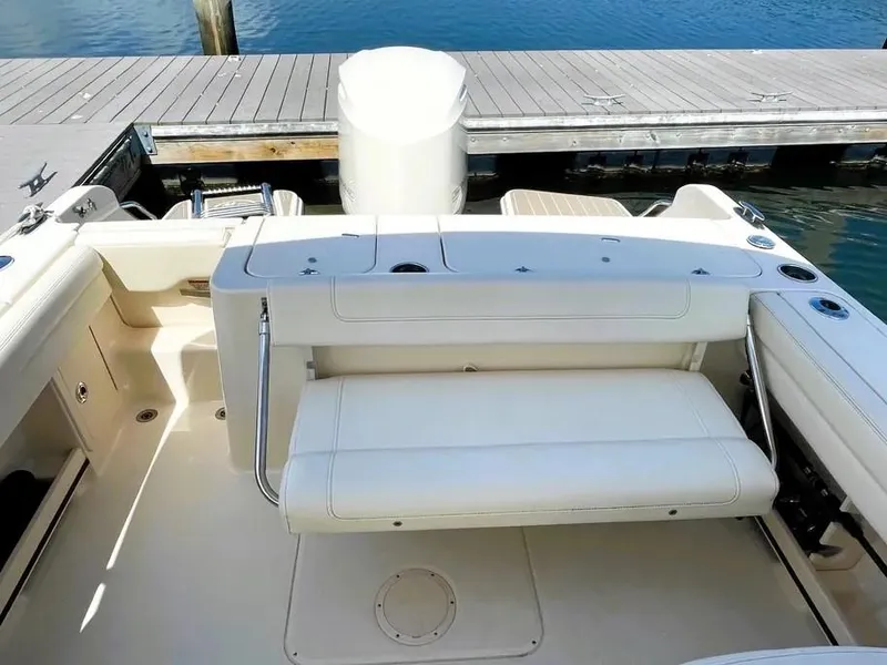 Slide: The Image of 2021 Grady-White Freedom 235 boat interior with seating, docked by the water. - 12