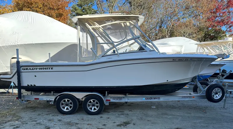 Slide: The Image of 2021 Grady-White Freedom 235 boat on trailer, parked outdoors with autumn trees. - 2