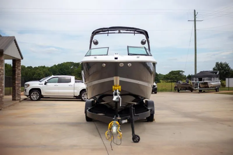 Slide: The Image of 2025 Four Winns H6 boat on trailer, parked outdoors near a white truck. - 3