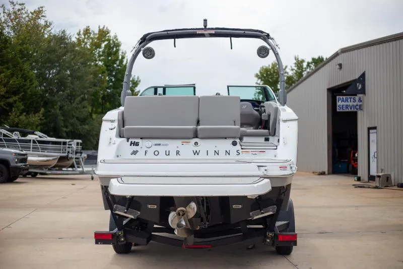Slide: The Image of 2025 Four Winns H6 boat, rear view, parked near service building. - 4