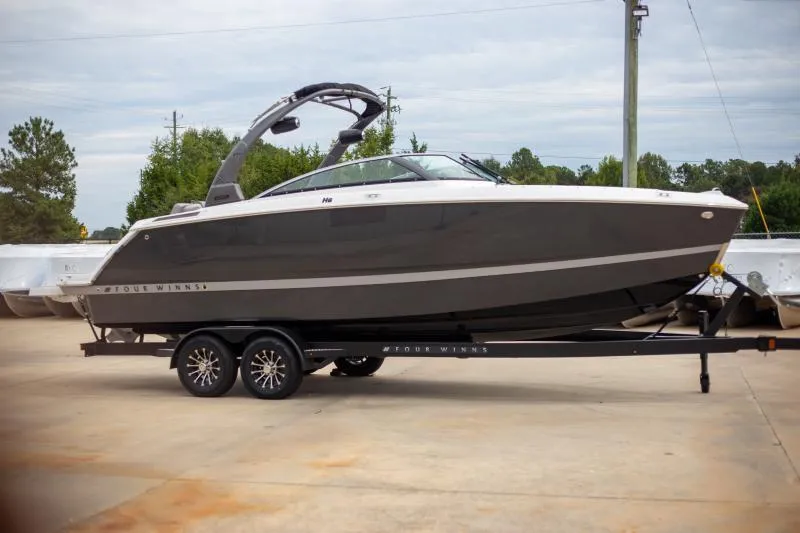 The Image of 2025 Four Winns H6 boat on trailer, sleek design, parked outdoors. - 1