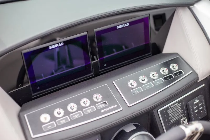 Slide: The Image of 2025 Four Winns H6 boat dashboard with dual Simrad displays and control panel. - 16