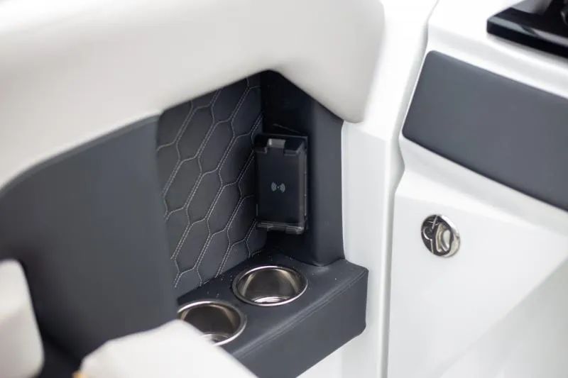 Slide: The Image of Interior detail of 2025 Four Winns H6 boat, featuring cup holders and a phone holder. - 17