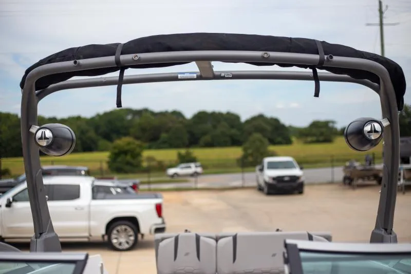 Slide: The Image of 2025 Four Winns H6 boat with speakers, parked near trucks, and a scenic background. - 18