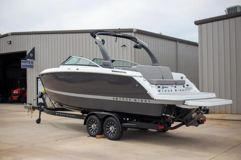 Slide: The Image of 2025 Four Winns H6 boat on trailer near service building. - 2