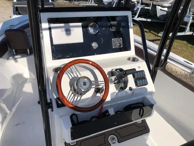 Slide: The Image of 2024 Reflex Gladiator boat dashboard with wooden steering wheel and modern controls. - 12