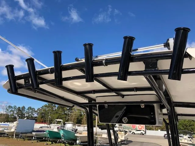 Slide: The Image of 2024 Reflex Gladiator boat with rod holders under a clear blue sky. - 23