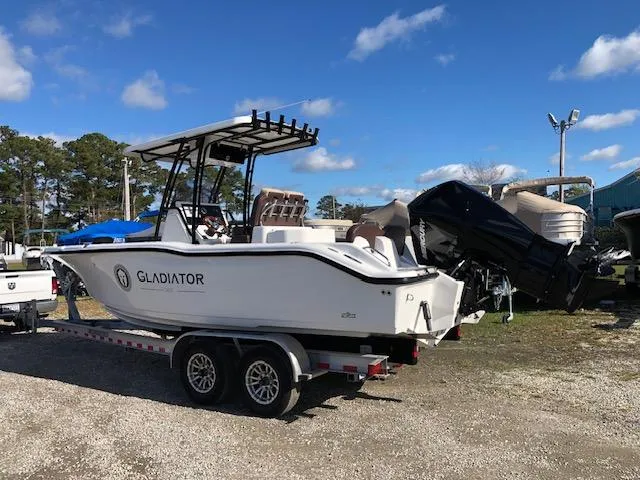 Slide: The Image of 2024 Reflex Gladiator boat on trailer under clear blue sky. - 7