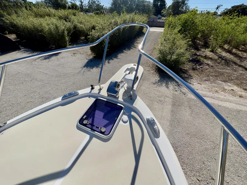 Slide: The Image of 2016 Marlow Pilot 31 boat deck with railing and hatch, surrounded by greenery. - 14