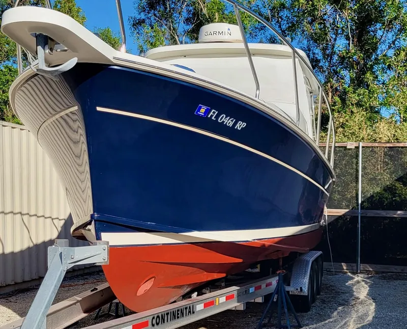 Slide: The Image of 2016 Marlow Pilot 31 boat on trailer, blue hull, Garmin equipment, outdoor setting. - 2