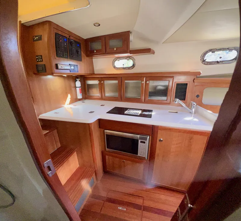 Slide: The Image of 2016 Marlow Pilot 31 yacht interior kitchen with wood cabinetry and modern appliances. - 25