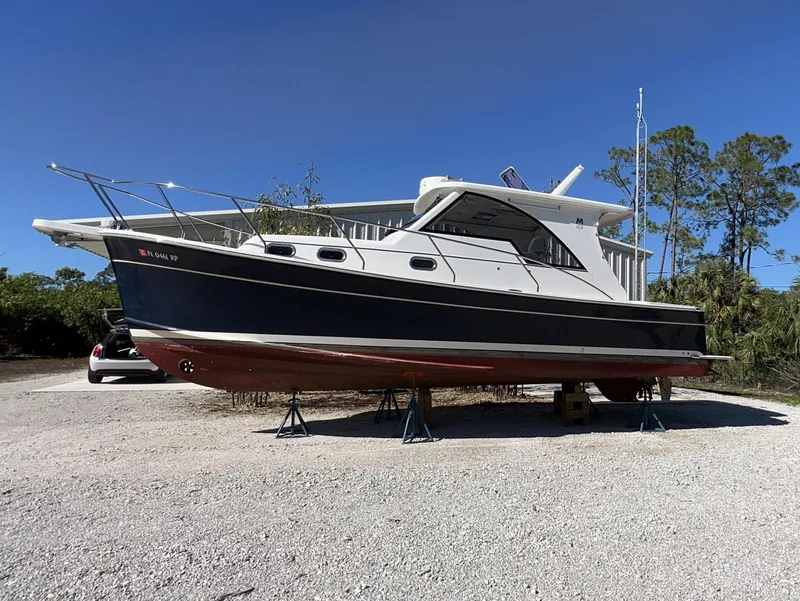 Slide: The Image of 2016 Marlow Pilot 31 boat on stands, outdoors under clear blue sky. - 3