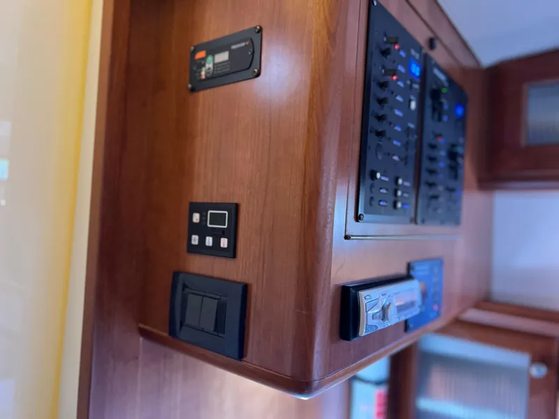 Slide: The Image of Control panel inside 2016 Marlow Pilot 31 Pilot boat, featuring wooden cabinetry and electronic displays. - 32