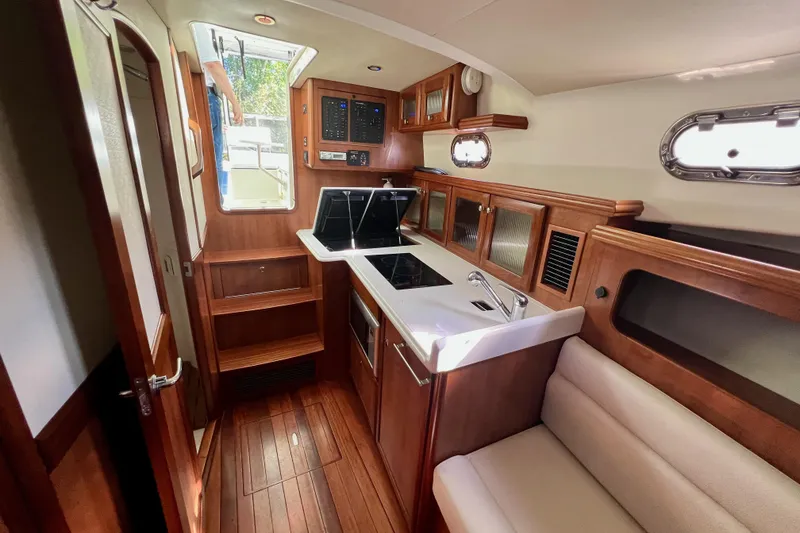 Slide: The Image of Interior of 2016 Marlow Pilot 31, featuring a compact kitchen and seating area. - 33