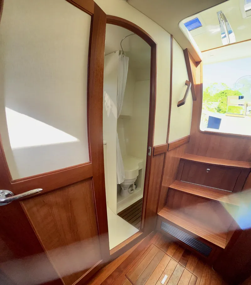 Slide: The Image of Interior of 2016 Marlow Pilot 31, featuring wooden cabinetry and compact bathroom. - 40
