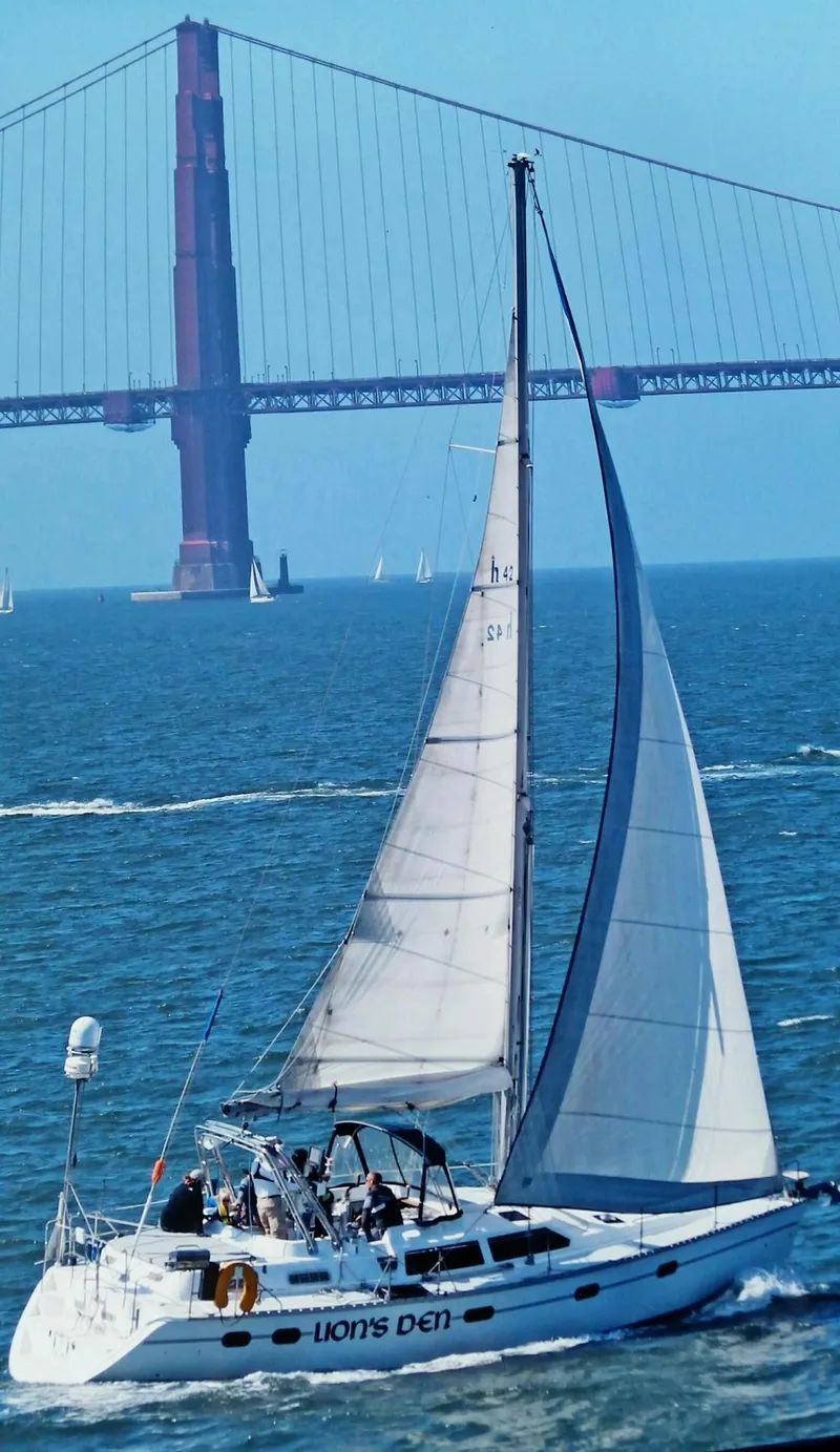 The Image of 1998 Hunter Passage 42 sailboat docked by a serene forested shoreline. - 0