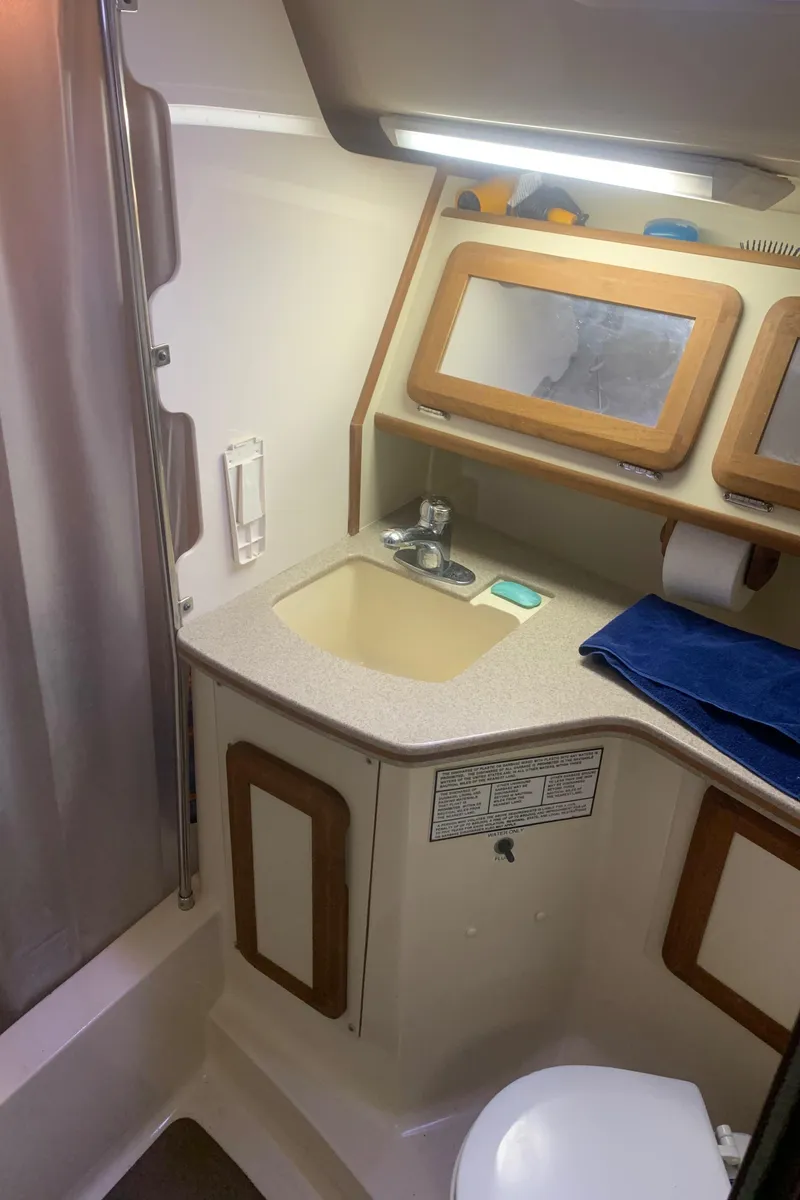 Slide: The Image of 1998 Hunter Passage 42 yacht bathroom with sink, mirror, and storage. - 11