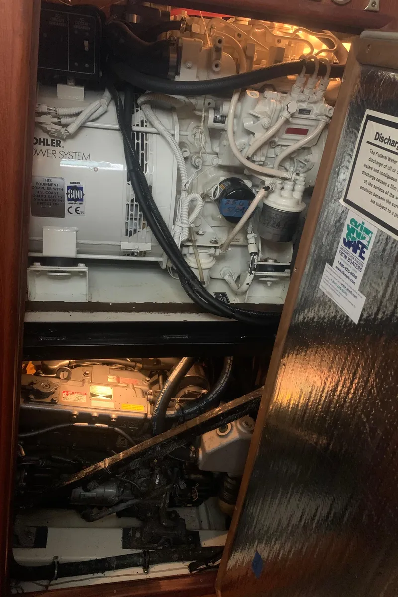 Slide: The Image of Engine compartment of 1998 Hunter Passage 42 sailboat, showing mechanical components and wiring. - 13