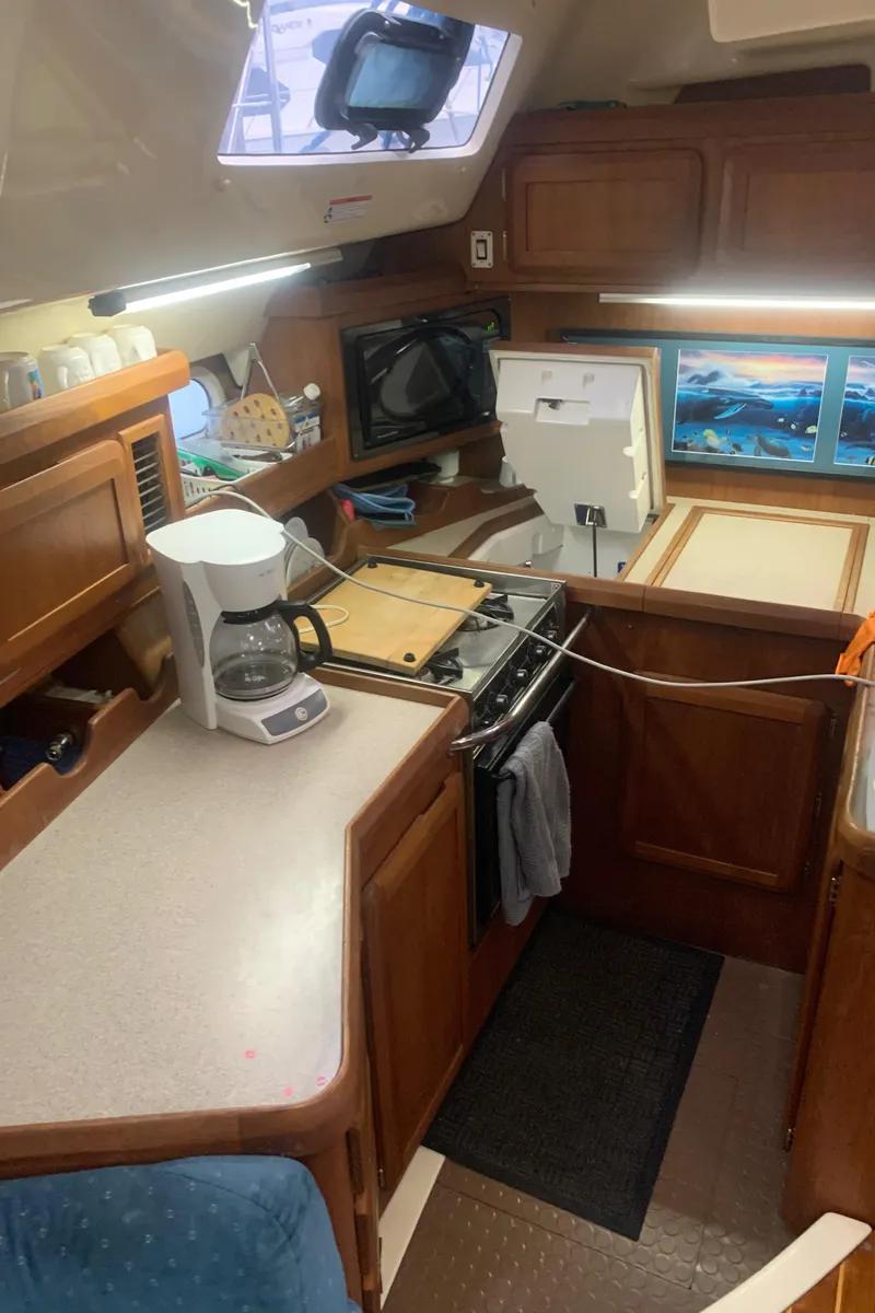 Slide: The Image of Interior of 1998 Hunter Passage 42 yacht with blue sofa and wooden cabinetry. - 8