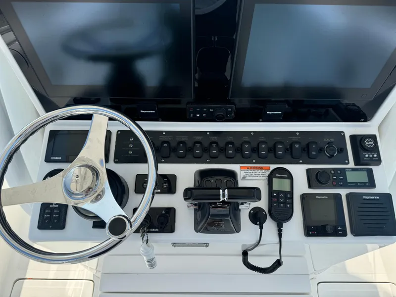Slide: The Image of 2017 Buddy Davis 34 cc boat dashboard with steering wheel and electronic controls. - 25
