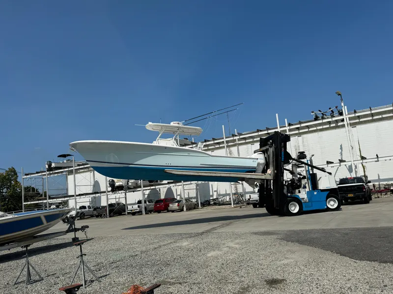 Slide: The Image of 2017 Buddy Davis 34 cc boat lifted by forklift in marina. - 27