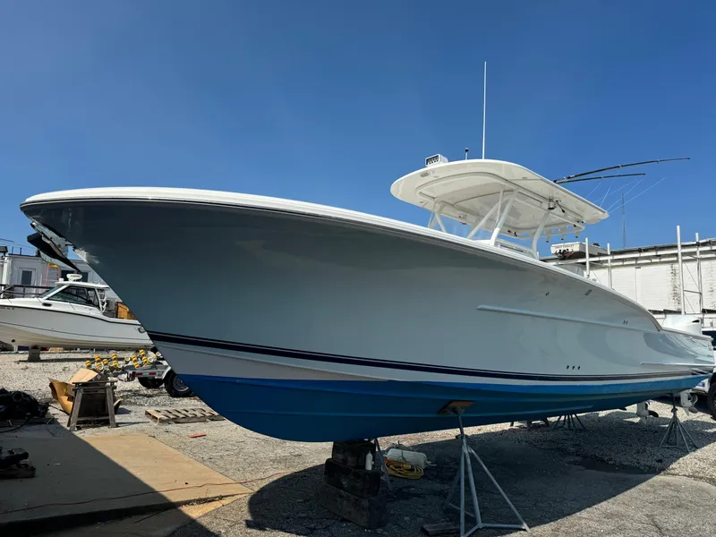 Slide: The Image of 2017 Buddy Davis 34 CC boat on stands under clear blue sky. - 4