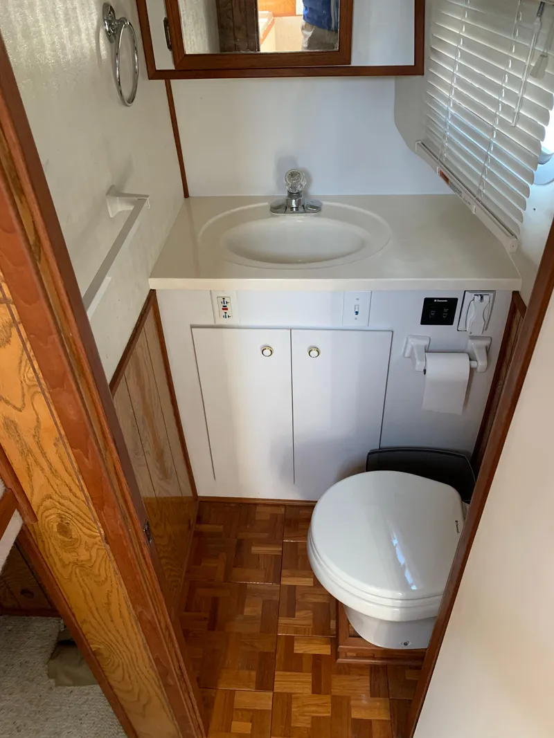 Slide: The Image of 1996 Harbor Master 460 WIDEBODY bathroom with sink, toilet, and wood accents. - 15
