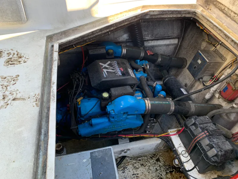 Slide: The Image of Engine compartment of 1996 Harbor Master 460 WIDEBODY boat, featuring a blue engine. - 24