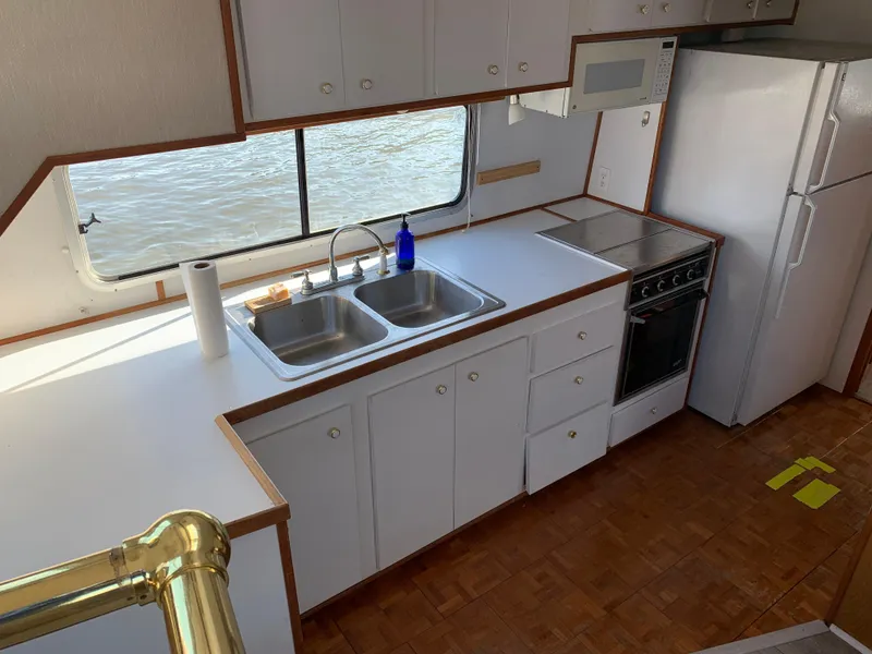 Slide: The Image of 1996 Harbor Master 460 WIDEBODY kitchen with dual sinks, stove, and large window view. - 9