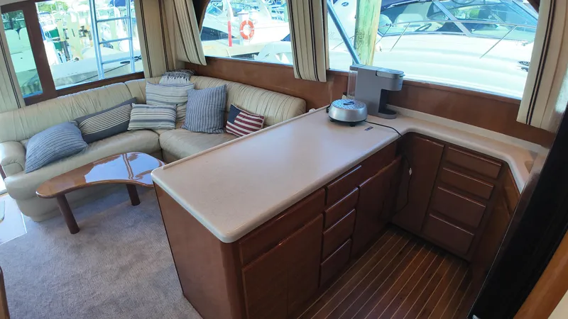 Slide: The Image of Interior of 1999 Viking 47 Convertible yacht with cozy seating and modern kitchen area. - 16