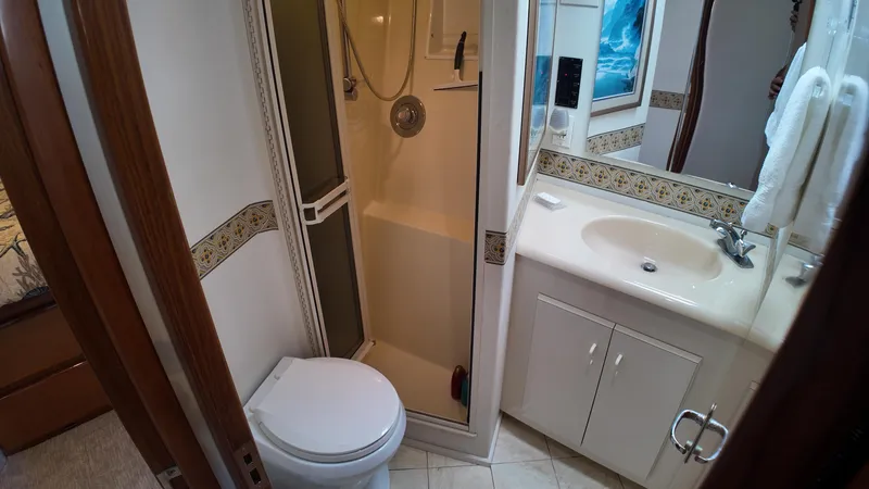 Slide: The Image of Bathroom interior of 1999 Viking 47 Convertible yacht with shower, toilet, and sink. - 21