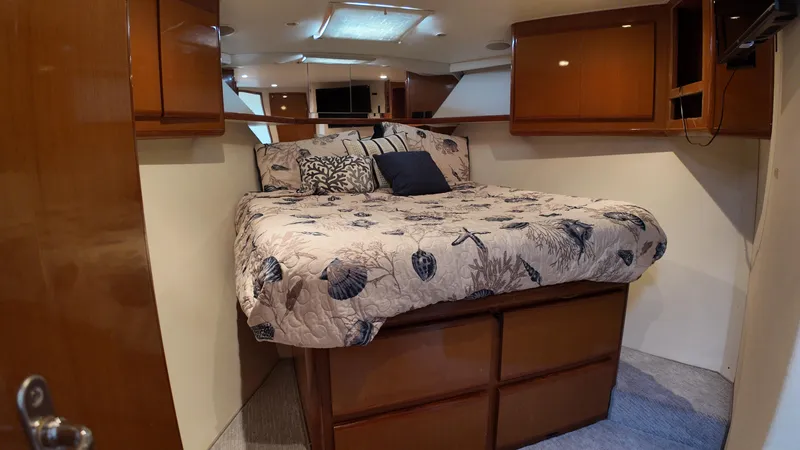 Slide: The Image of Cozy bedroom in 1999 Viking 47 Convertible yacht with nautical-themed bedding. - 22