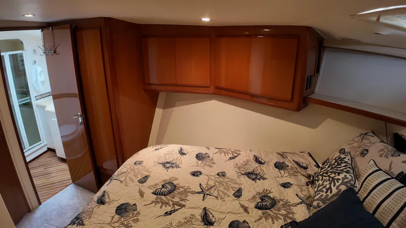 Slide: The Image of Cozy bedroom in 1999 Viking 47 Convertible yacht with nautical-themed bedding. - 24