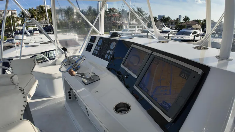 Slide: The Image of 1999 Viking 47 Convertible yacht helm with navigation screens and steering wheel. - 28