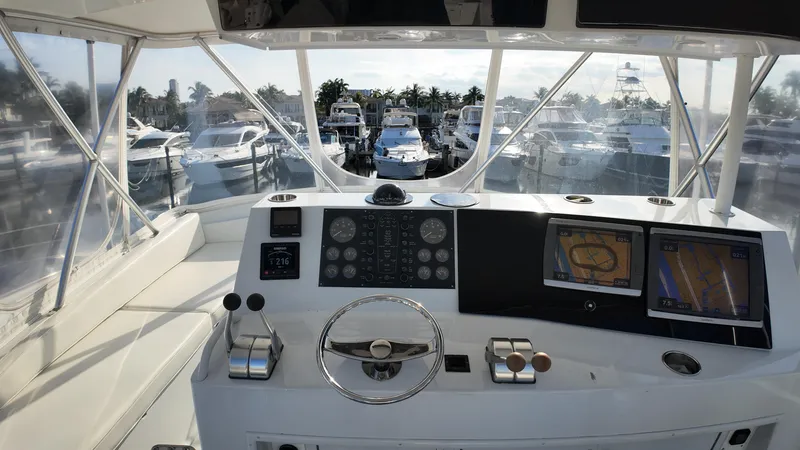 Slide: The Image of 1999 Viking 47 Convertible yacht helm with navigation screens and marina view. - 31