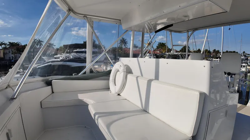 Slide: The Image of 1999 Viking 47 Convertible yacht interior with white seating and marina view. - 34