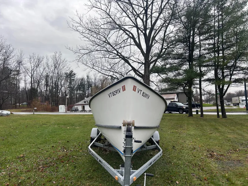 Slide: The Image of 2020 Flying Point Boatworks FP 21 on trailer, parked on grass with trees in background. - 6